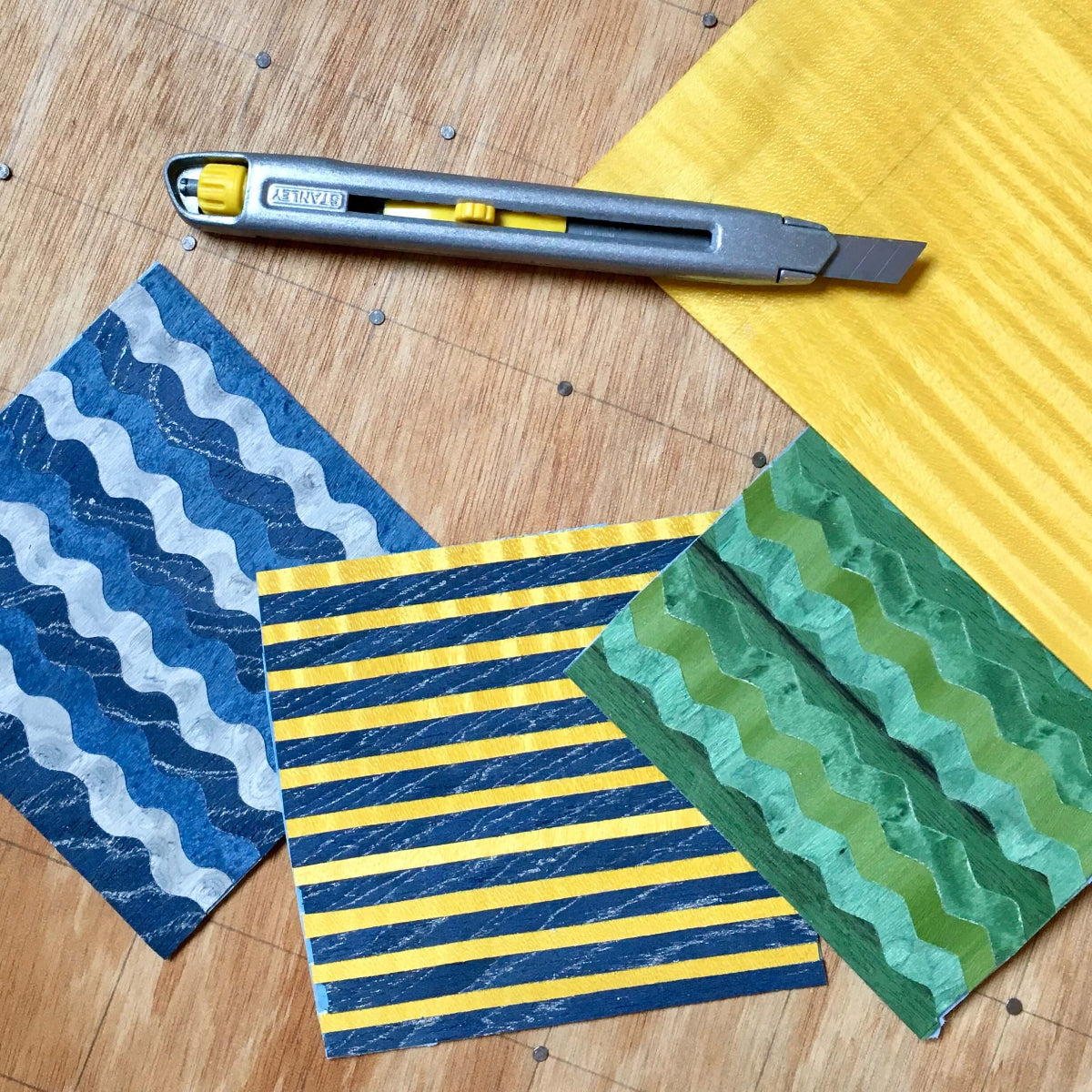 Exercices de découpe et motifs géométriques colorés en marqueterie de bois, réalisés pendant un stage d’initiation à l’Atelier Nathalie Melon.