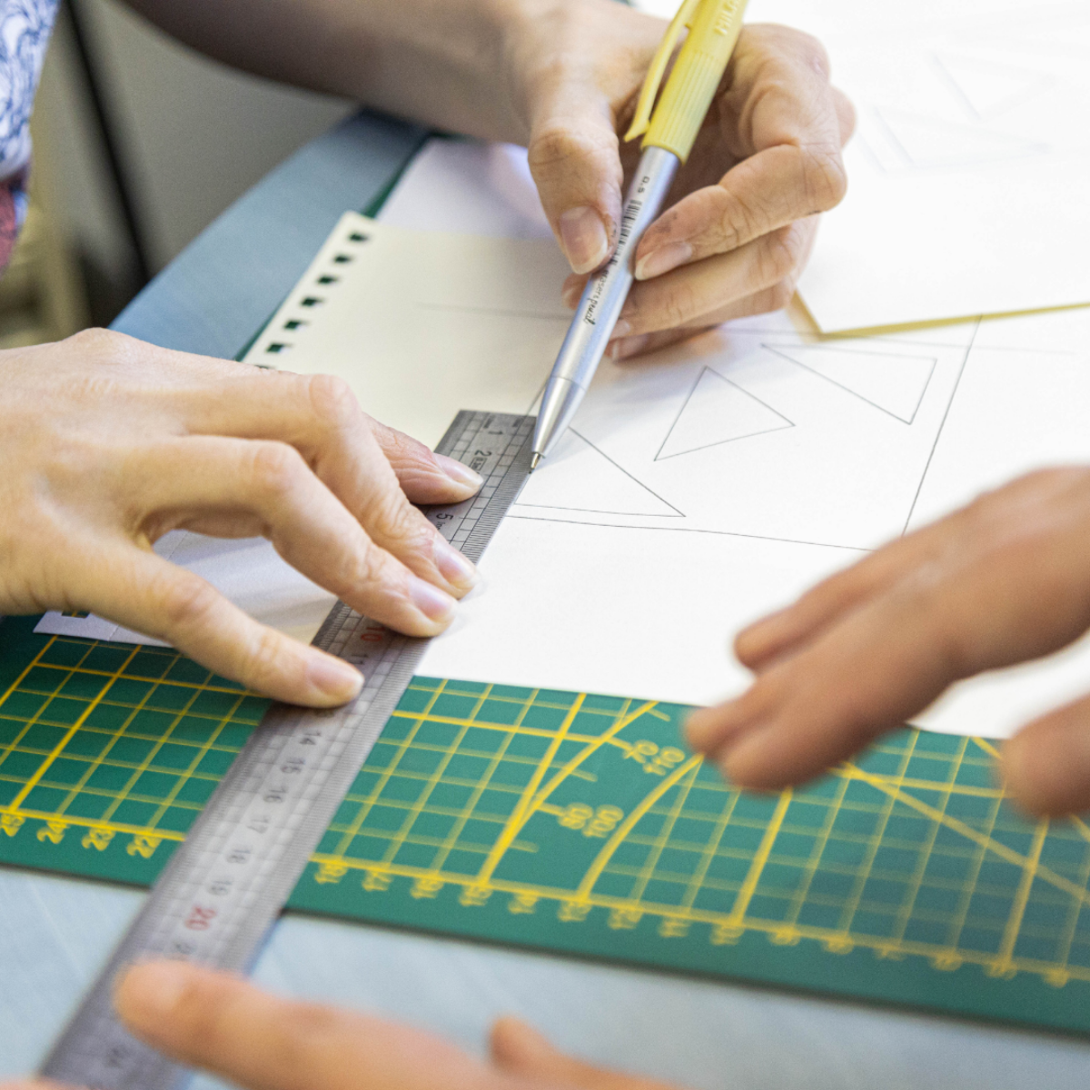 Étape de traçage des motifs géométriques sur papier lors de l’atelier dessous de verre en marqueterie bois. Une initiation pratique pour concevoir des objets décoratifs personnalisés.