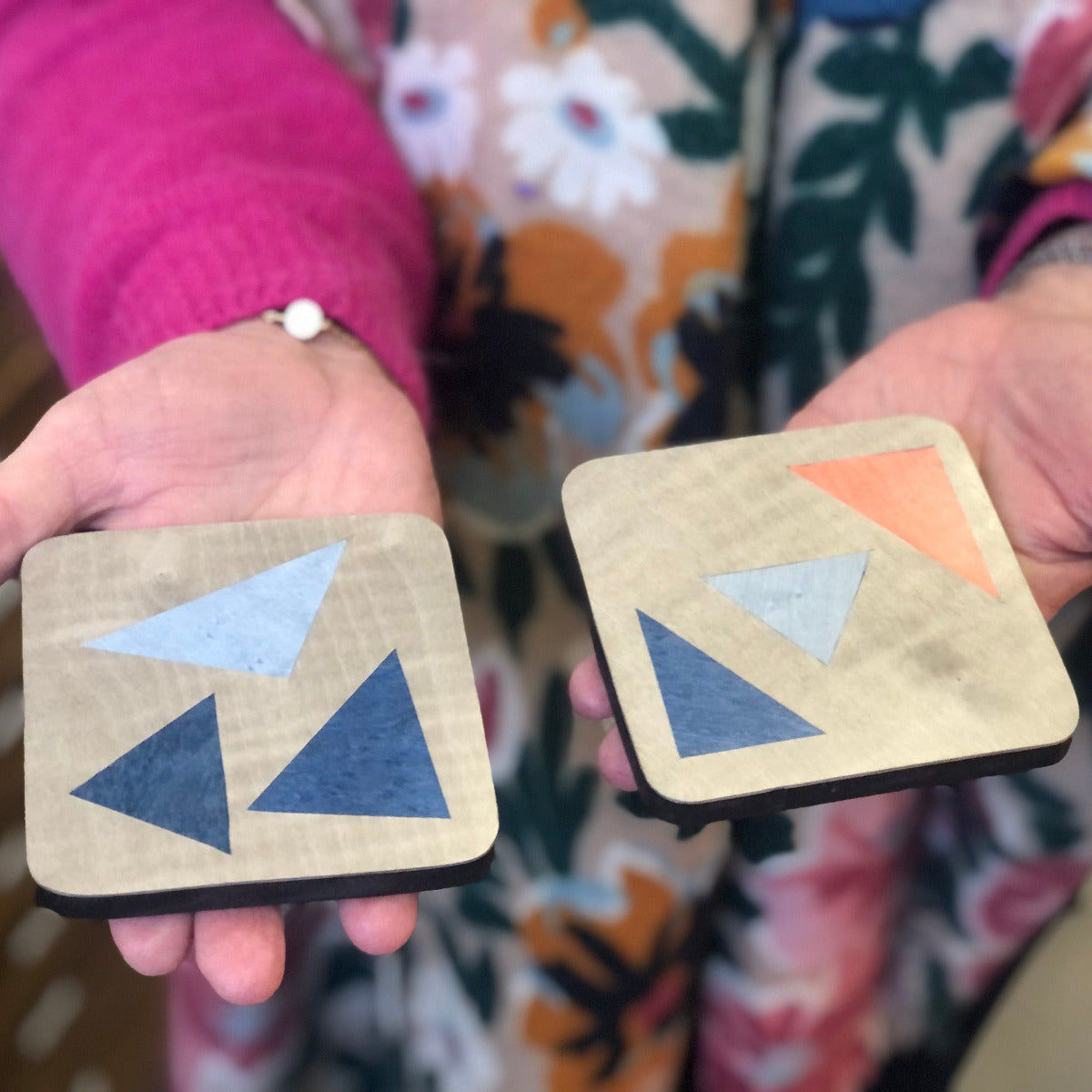 Dessous de verre réalisés en marqueterie contemporaine, présentant des motifs géométriques aux tons bleus et corail. Un travail précis et minutieux alliant créativité et savoir-faire artisanal.