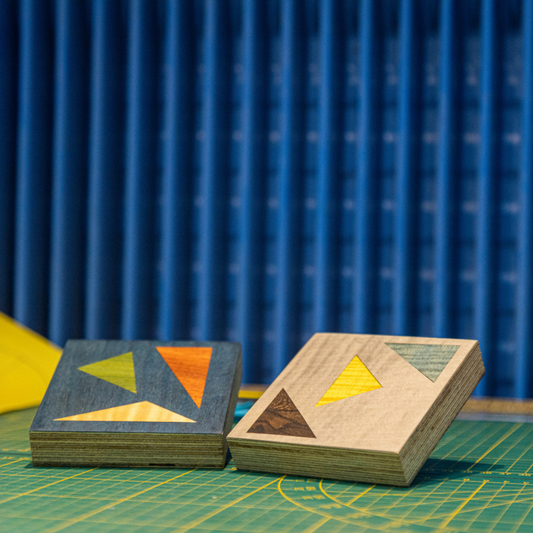 Dessous de verre artisanaux fabriqués en marqueterie bois avec des motifs géométriques colorés. Créations réalisées dans le cadre des ateliers et stages de marqueterie d'Atelier Nathalie melon à Nancy, mettant en avant un savoir-faire manuel.