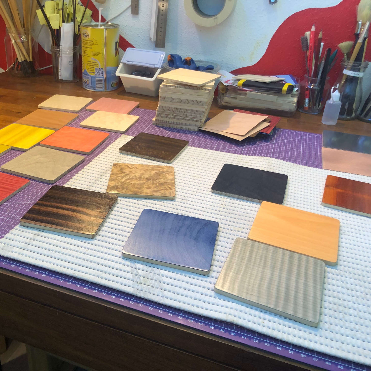 Sélection d’échantillons de placages en bois colorés présentés sur l’établi de l’Atelier Nathalie Melon à Nancy, lors du stage d'initiation à la marqueterie