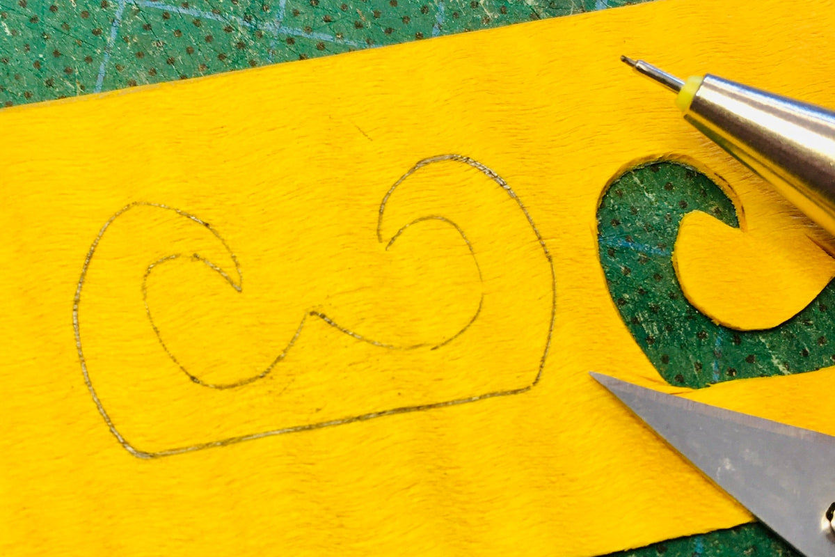 Dessin et découpe d’un motif sur placage de bois coloré pendant le stage projet personnel en marqueterie bois à l’Atelier Nathalie Melon.